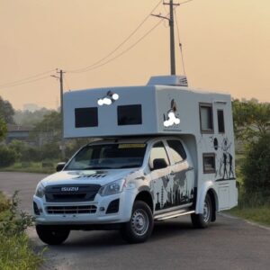 "White campervan parked near a scenic mountain lake under a clear blue sky"