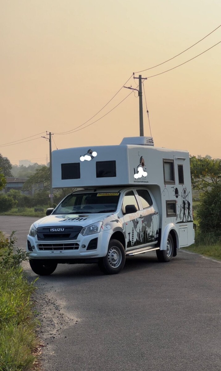 "White campervan parked near a scenic mountain lake under a clear blue sky"